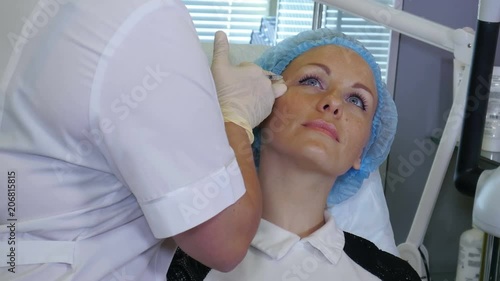 Hands of cosmetologist making injection in face photo