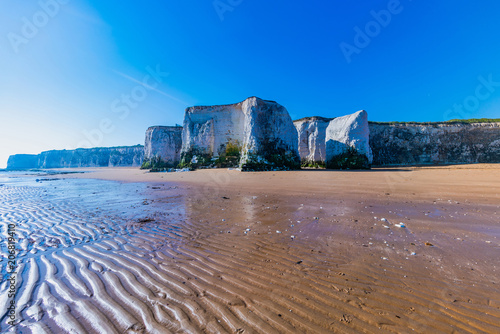 View of white chalk stacks, cliffs, sea at low tide and beach in Botany Bay, Margate, East Kent, UK photo