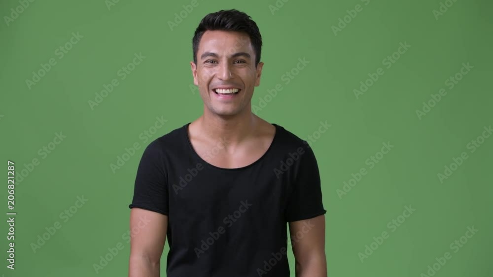 Young handsome Hispanic man against green background Young handsome Hispanic man against green background