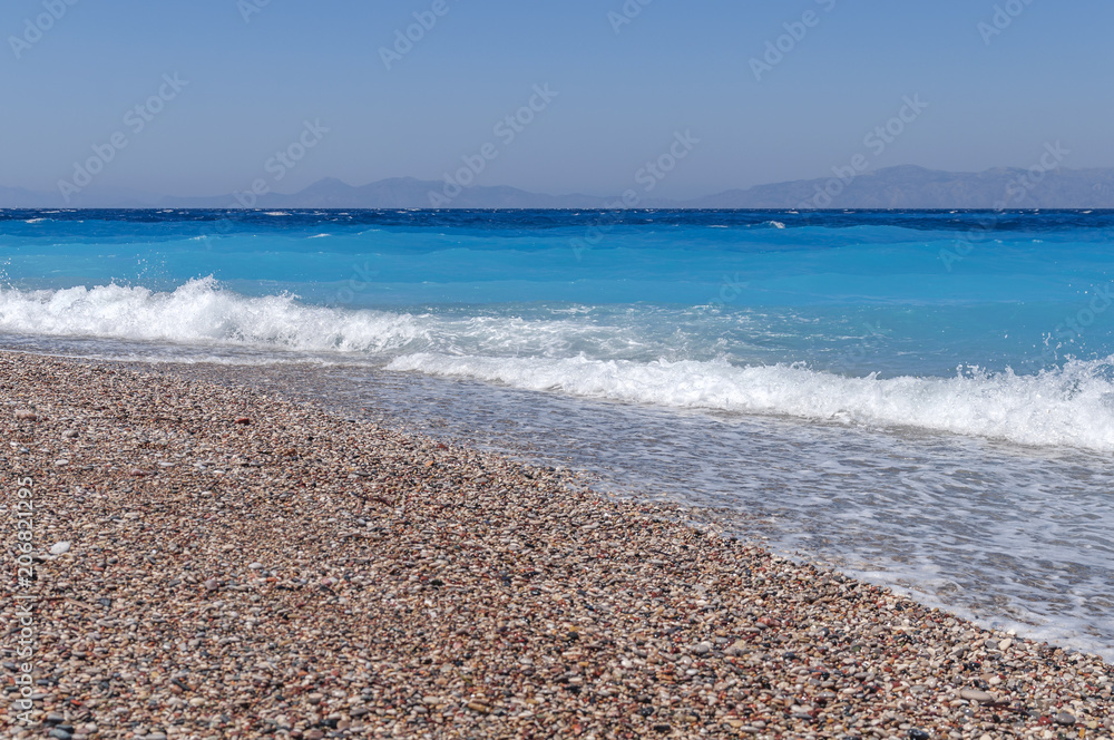 Small wave and sand pebble beach with bubbles with clean sky Small wave and sand pebble beach with bubbles with clean sky