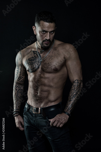 Tattoo model with six pack and ab. Bearded man with tattooed body. Man with  sexy bare torso in jeans. Athlete or sportsman with muscular chest and  belly. Sport or fitness and bodycare,