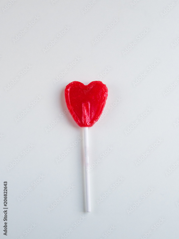 Red heart lollipop on white background