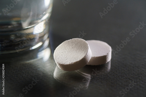 Glass with efervescent tablet in water with bubbles isolated on white photo