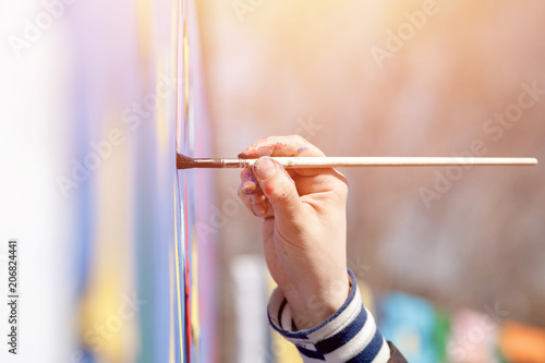 Close-up of girl holding hand brush for painting, drawing, glare of sun