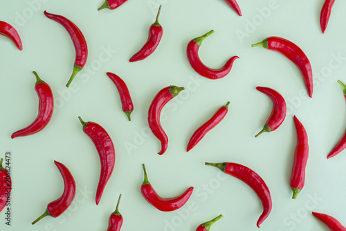 Red hot chilli pepper on green background, frame, flatlay photo