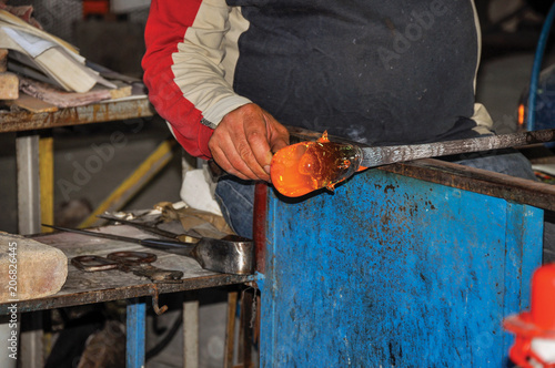 Detail of craftsman hands working on glass sculpture in a Murano workshop, a small and pleasant town on top of islands near Venice. Located in the Veneto region, northern Italy © Celli07