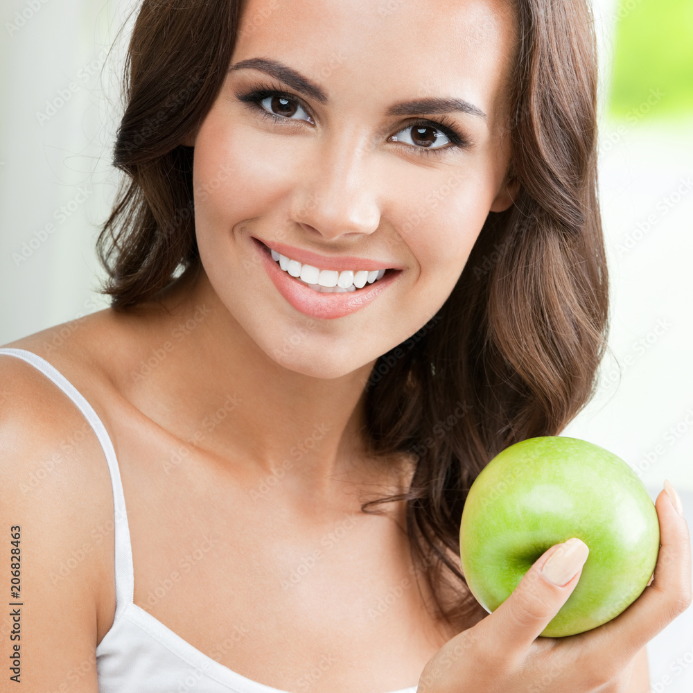 Young happy smiling woman with apple, indoors Young happy smiling woman with apple, indoors