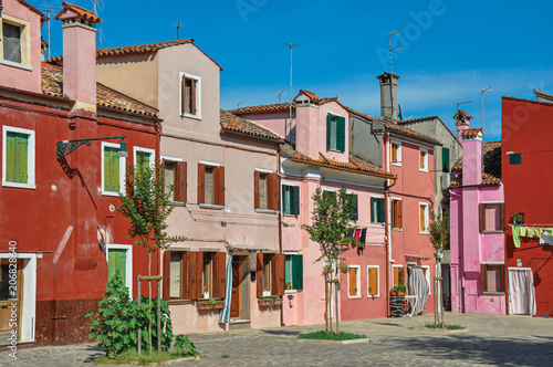 Overview of colorful terraced houses on sunny day in Burano, a gracious little town full of canals, near Venice. Located in the Veneto region, northern Italy © Celli07