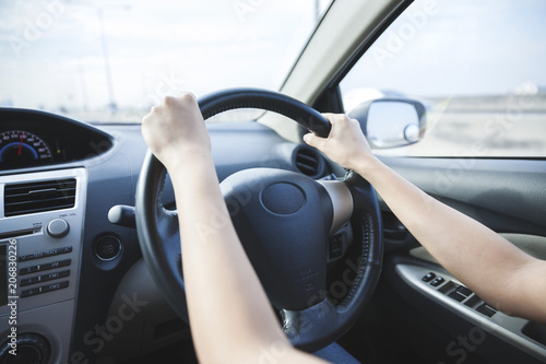 Close up of female hands on the steering © Suradech