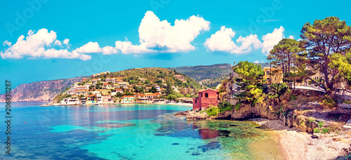 Fototapeta Naklejka Na Ścianę i Meble -  Beautiful landscape with bay and colorful buildings on the background of picturesque clouds in the town of Asos, Greece, Kefalonia. Wonderful exciting places. Panorama.