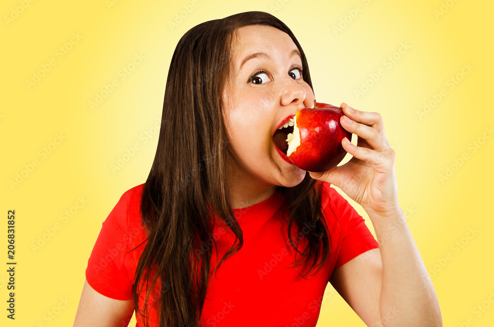 Young woman eats apple isolated on yellow background. Young woman eats apple isolated on yellow background.