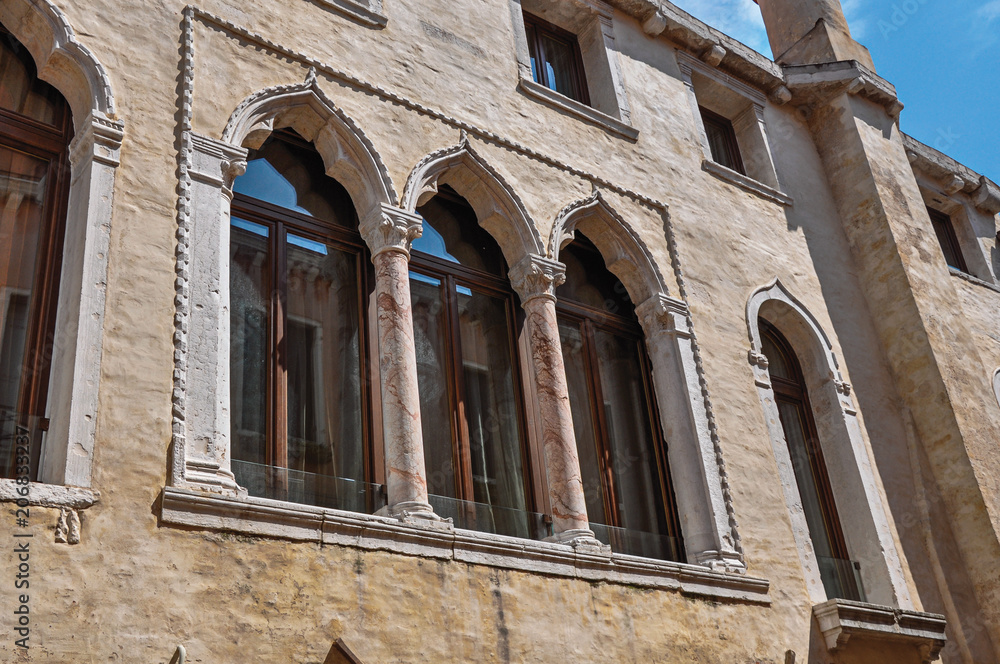 Close-up of windows with columns and arches in typical Venetian style in ancient building. At the city center of Venice, the historic and amazing marine city. Located in Veneto region, northern Italy