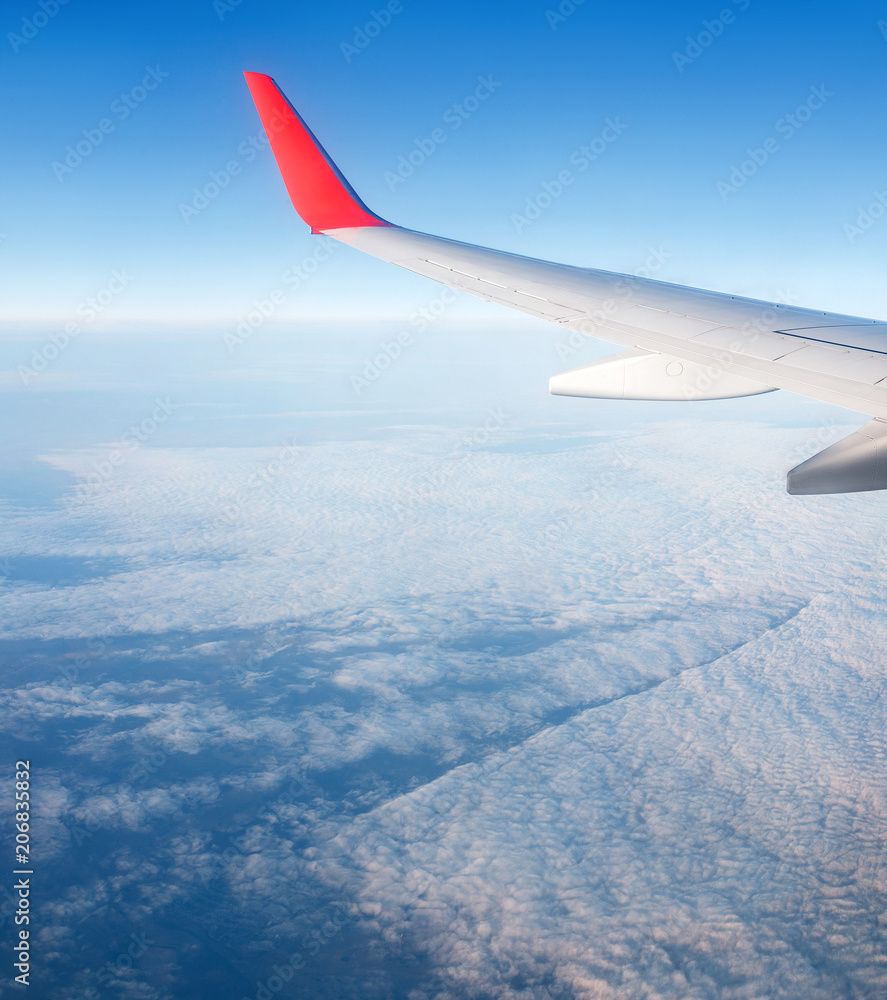 View from window of airplane on the blue sky and wing with sharklet