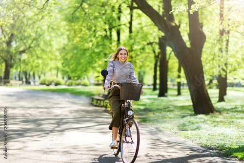 Attractive young woman cycling through the park