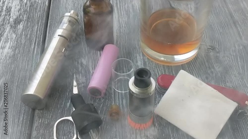 Still life with e-cig and jiuce on the wooden background photo