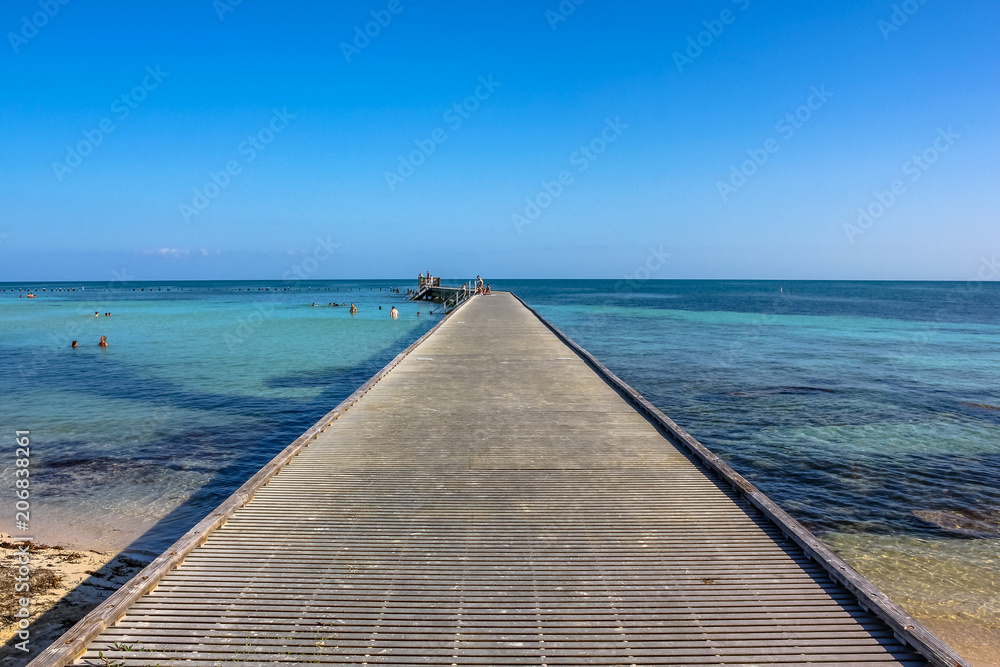 Wooden path at Higgs Beach, a popular Key West beach in Florida, United States. Infinity and freedom concept.