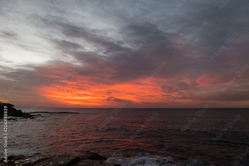 Red cloudy sky before the sunrise at Sydney coastline.