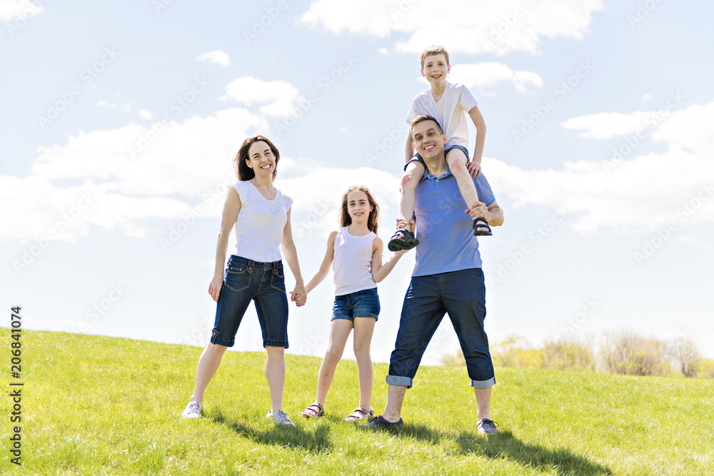 Family of four outdoors in a field having fun Family of four outdoors in a field having fun