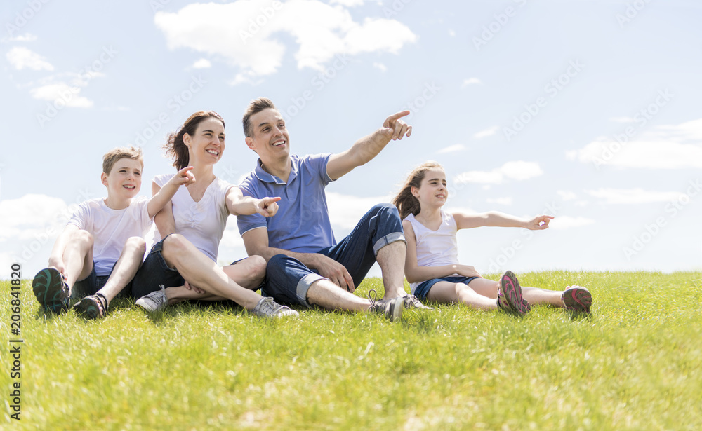 Family of four outdoors in a field having fun Family of four outdoors in a field having fun