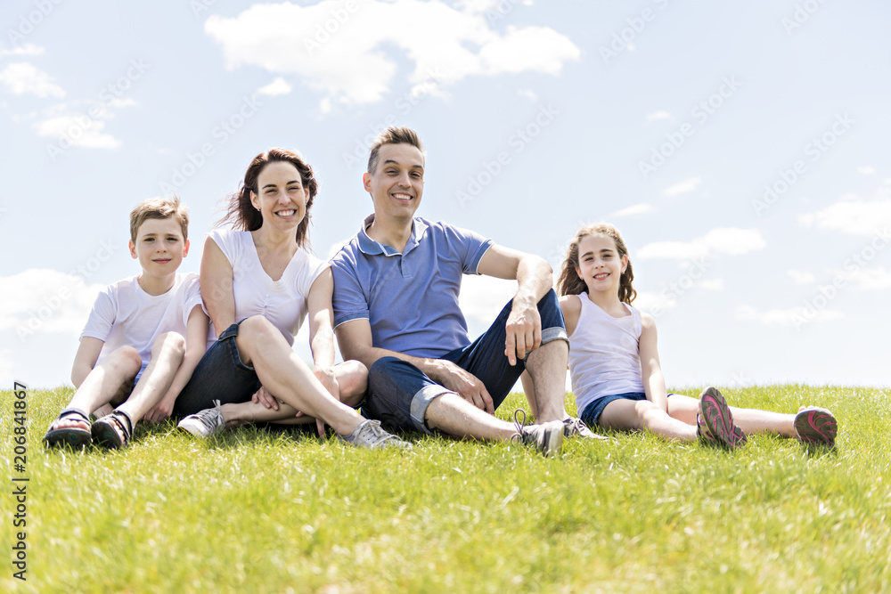 Family of four outdoors in a field having fun Family of four outdoors in a field having fun