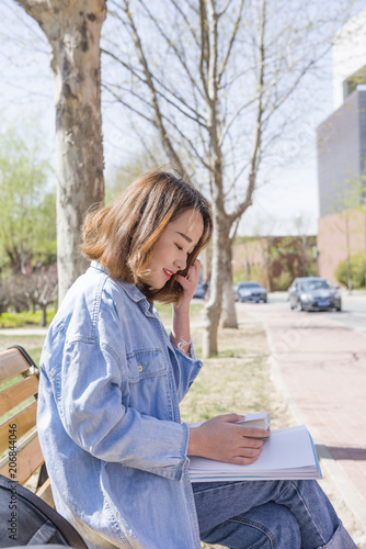 Young woman reading on bench