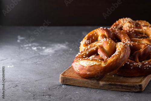 Obraz na plátně Freshly baked homemade soft pretzel with salt on rustic table