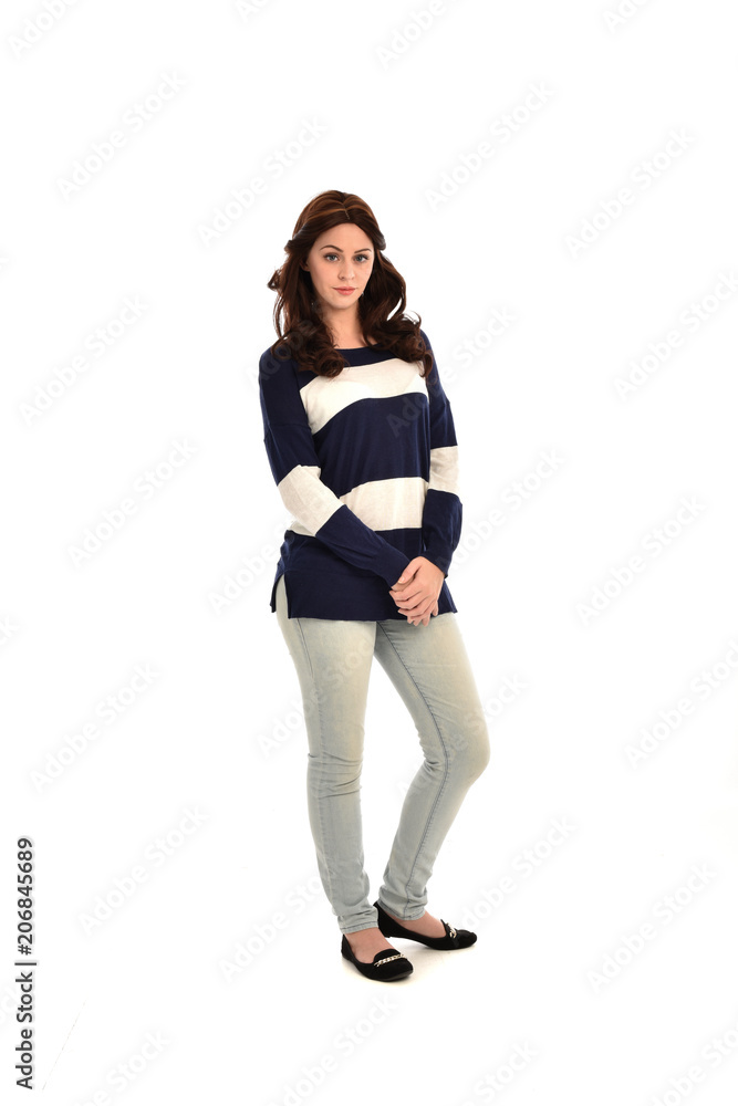 full length portrait of girl wearing striped blue and white jumper and jeans. standing pose on white studio background full length portrait of girl wearing striped blue and white jumper and jeans. standing pose on white studio background