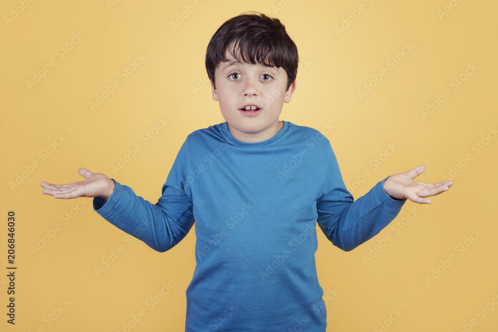 niño confuso que pregunta sobre fondo amarillo niño confuso que pregunta sobre fondo amarillo