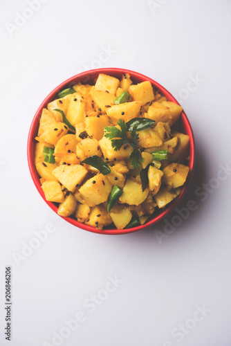 Chatpate Masala Aloo Sabzi fry OR Bombay potatoes served in a bowl, selective focus photo