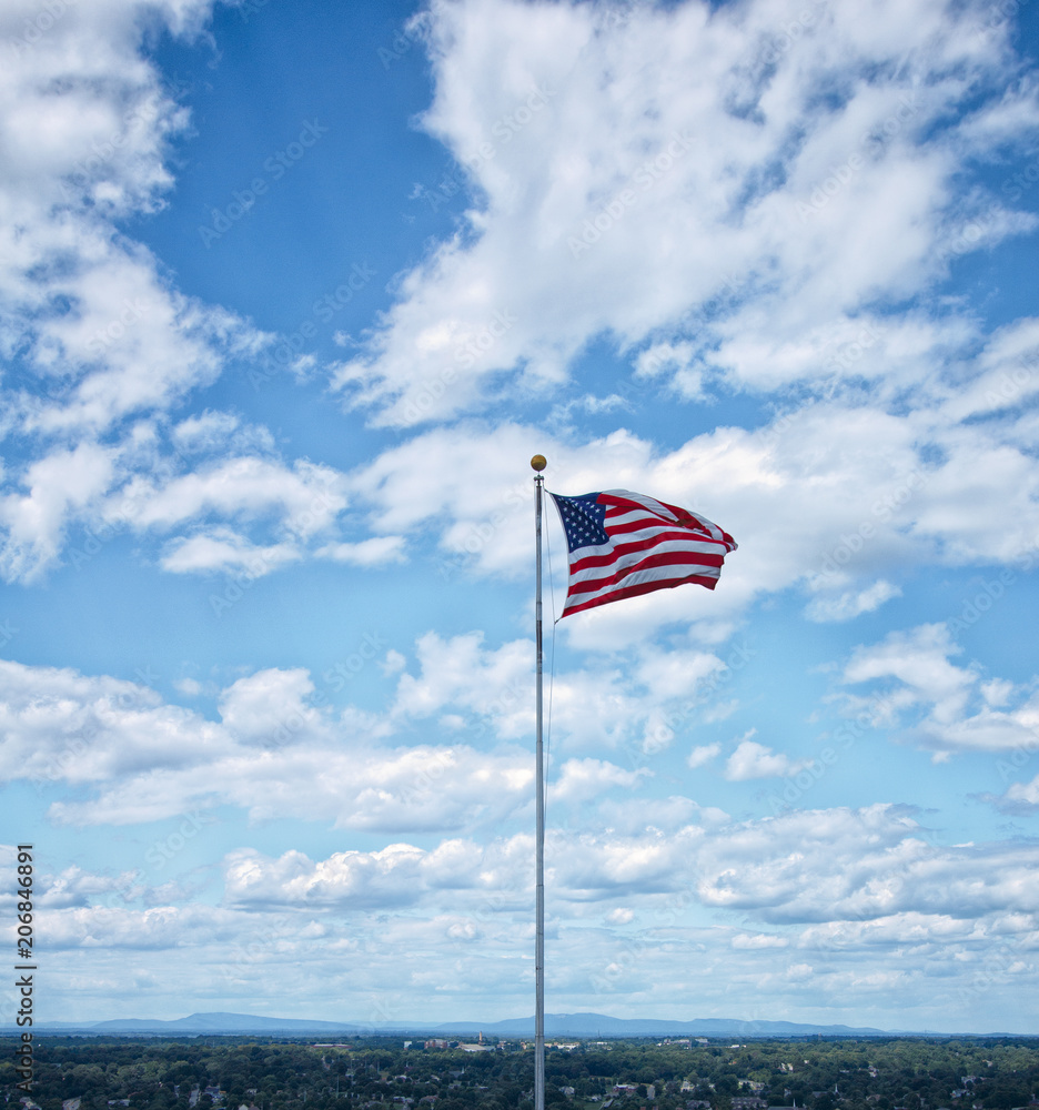 American Flag against Blue Sky and Mountains.