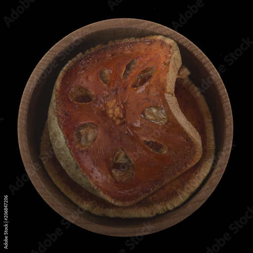 dried matum in wooden cup isolated on black. top view photo