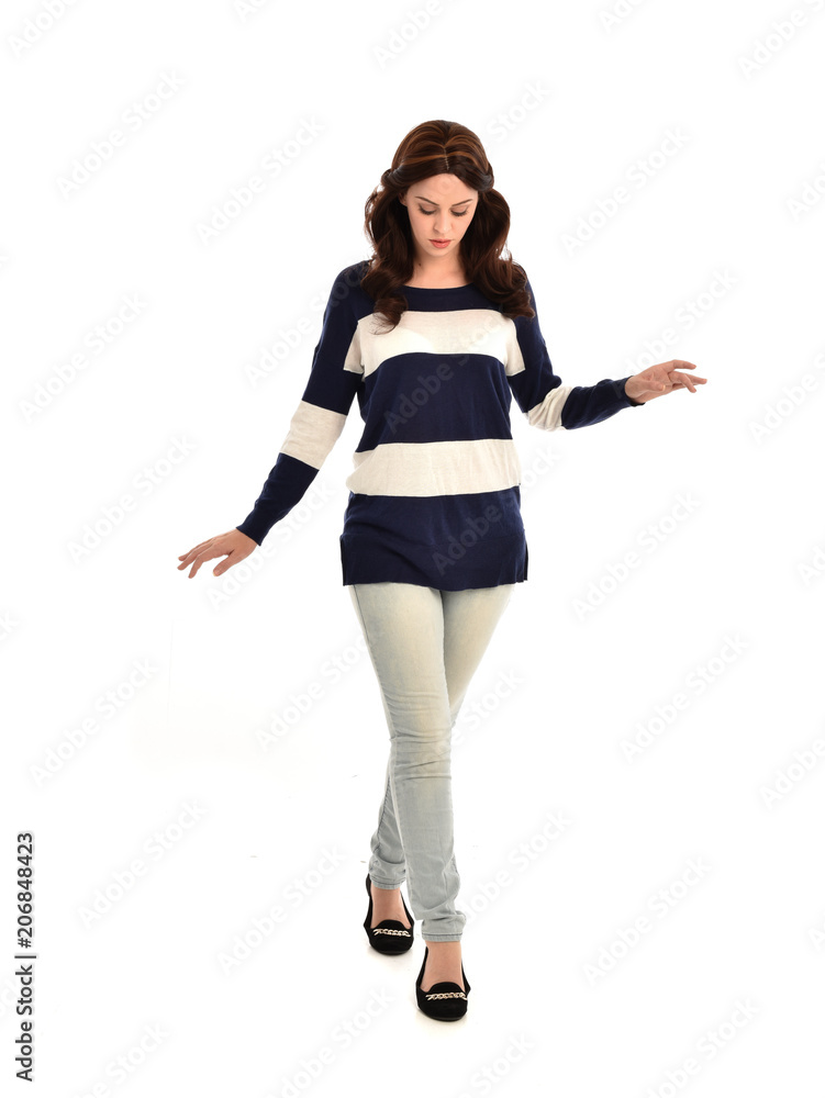 full length portrait of girl wearing striped blue and white jumper and jeans. standing pose on white studio background full length portrait of girl wearing striped blue and white jumper and jeans. standing pose on white studio background