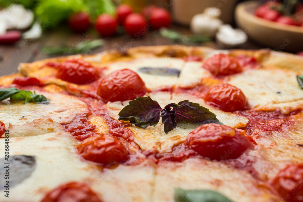 rustic italian pizza Margarita with mozzarella, cherry tomatoes and basil leaves on wooden background rustic italian pizza Margarita with mozzarella, cherry tomatoes and basil leaves on wooden background