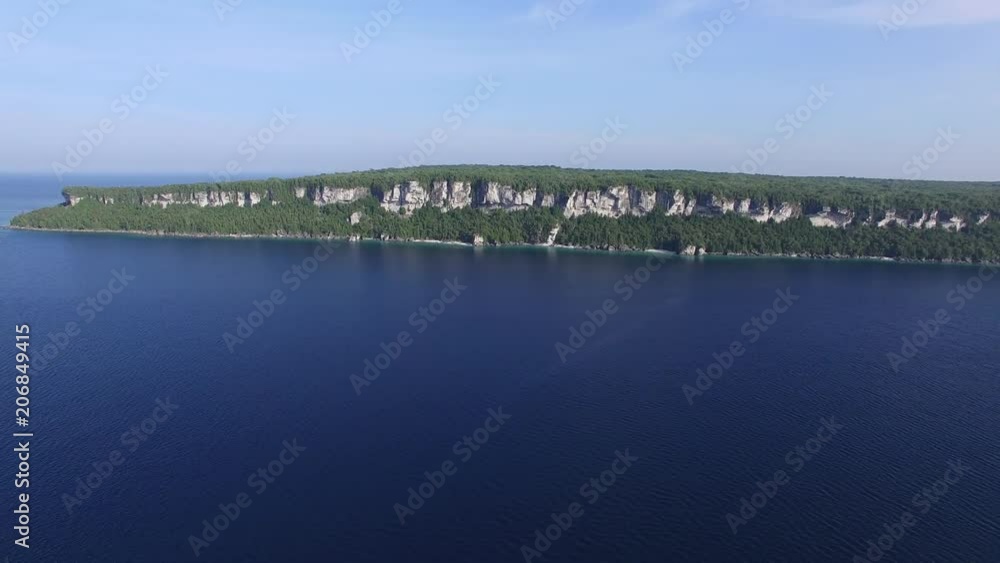 Drone flying away and exposing wide shoreline line with high rocky cliffs Drone flying away and exposing wide shoreline line with high rocky cliffs