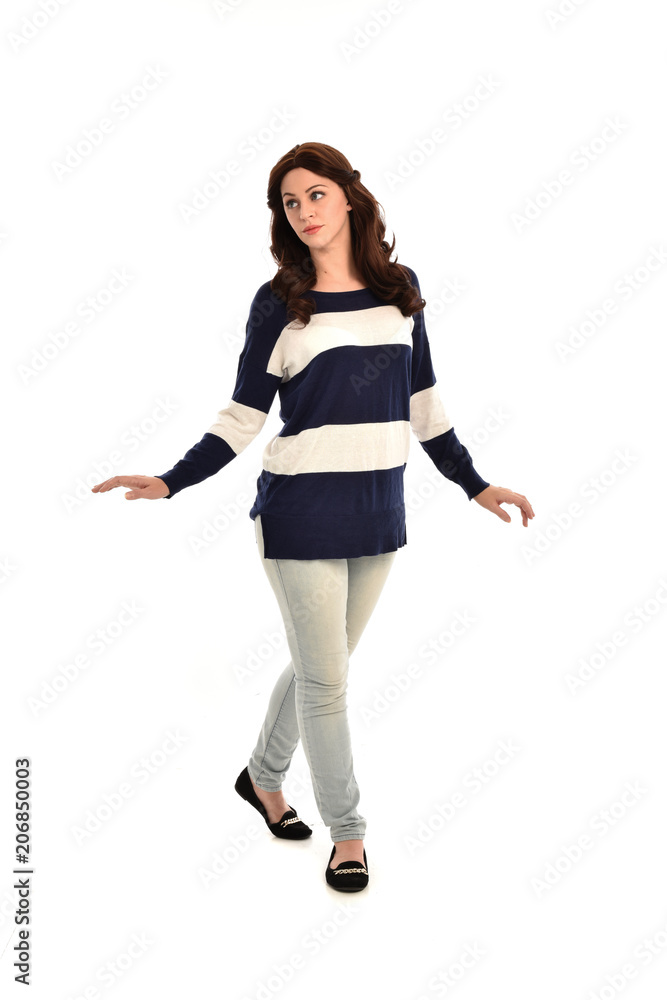full length portrait of girl wearing striped blue and white jumper and jeans. standing pose on white studio background full length portrait of girl wearing striped blue and white jumper and jeans. standing pose on white studio background