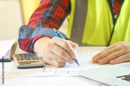 business concept of man working on drawing and engineering calculator in office