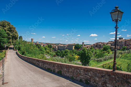 View of Colle di Val d Elsa town with bridge and vegetation at the front. A graceful village with its historic center preserved and known by its crystal production. Located in the Tuscany region photo