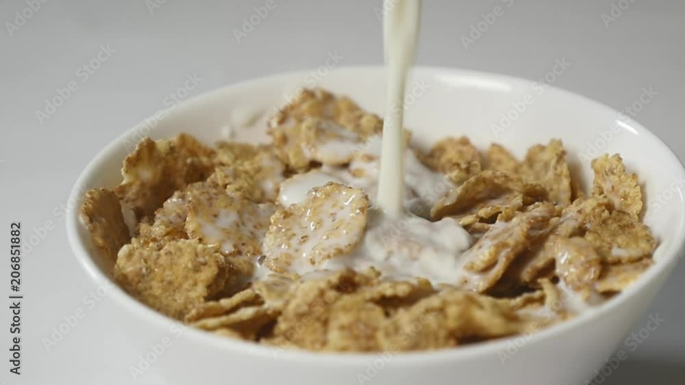 Pouring milk into cereal flakes Pouring milk into cereal flakes
