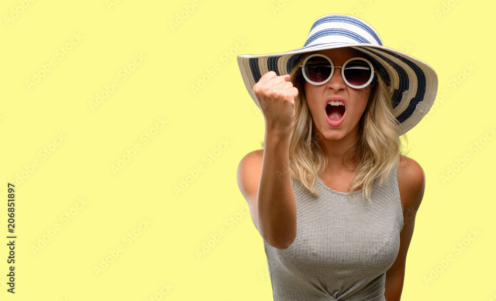 Young woman wearing sunglasses and summer hat irritated and angry expressing negative emotion, annoyed with someone Young woman wearing sunglasses and summer hat irritated and angry expressing negative emotion, annoyed with someone