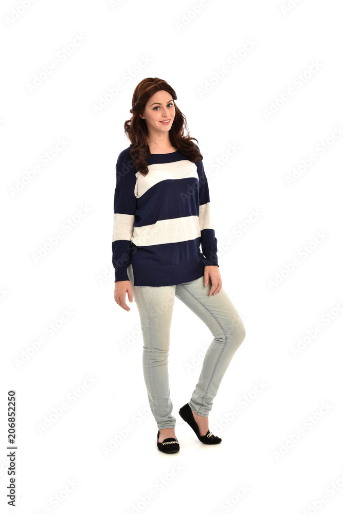 full length portrait of girl wearing striped blue and white jumper and jeans. standing pose on white studio background full length portrait of girl wearing striped blue and white jumper and jeans. standing pose on white studio background