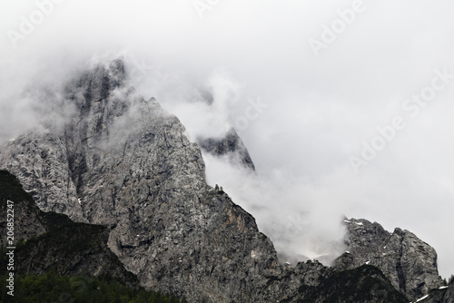 foggy clouds rising from dark alpine mountain forest © Björn