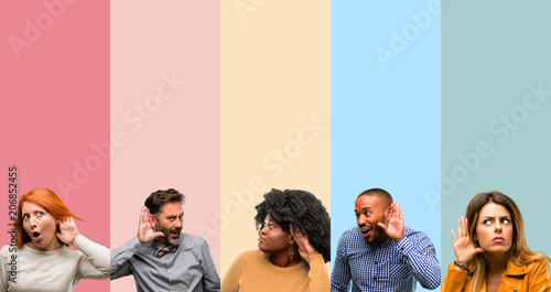 Cool group of people, woman and man holding hand near ear trying to listen to interesting news expressing communication concept and gossip