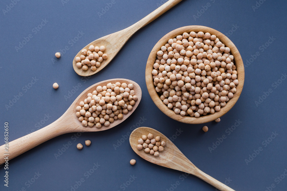 dry raw chickpeas in wooden bowl and spoons dry raw chickpeas in wooden bowl and spoons