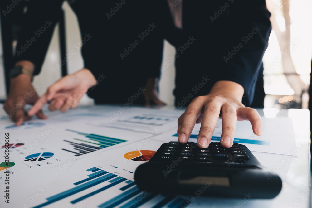 Close up Businessman and partner using calculator for calculating financial document, tax, accounting, statistics and analytic research concept