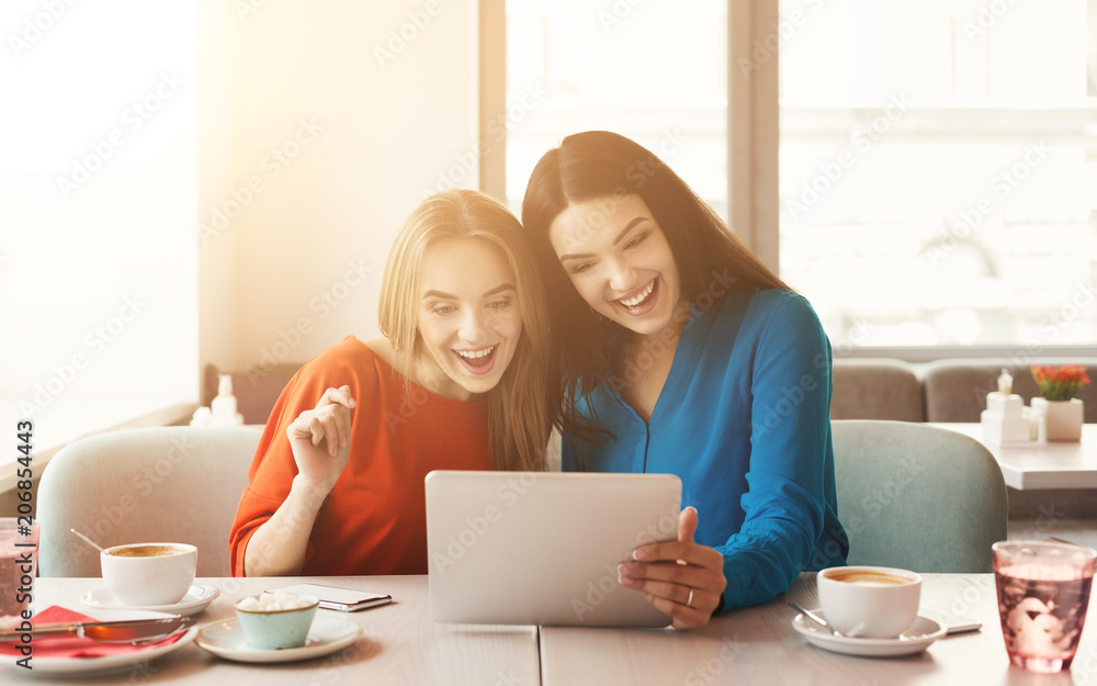 Happy female frinds with coffee and tablet at cafe Happy female frinds with coffee and tablet at cafe