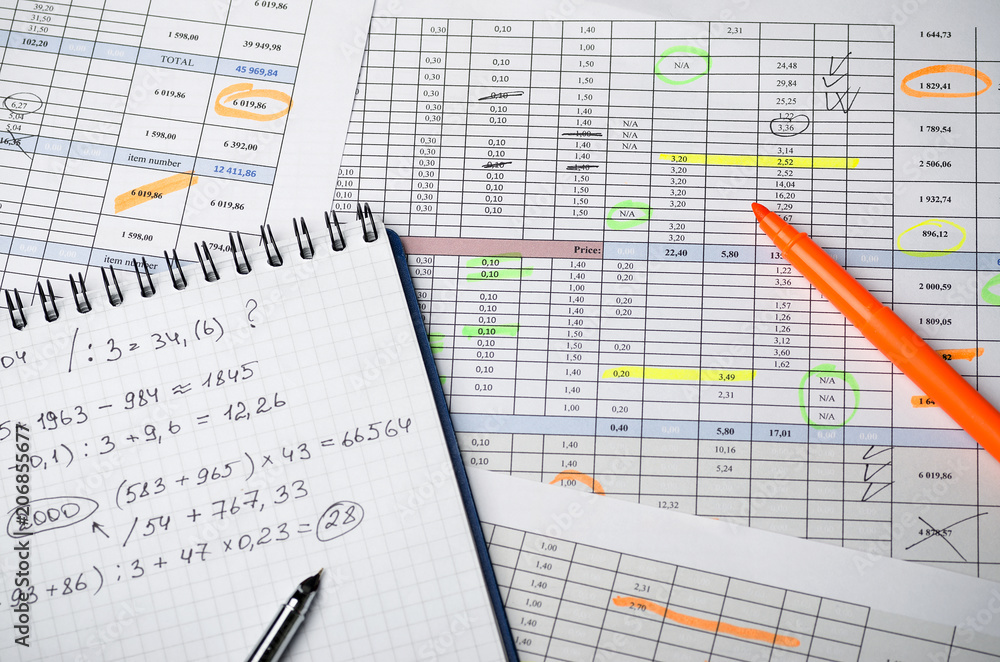 Financial tables on paper and a notebook with calculations Financial tables on paper and a notebook with calculations