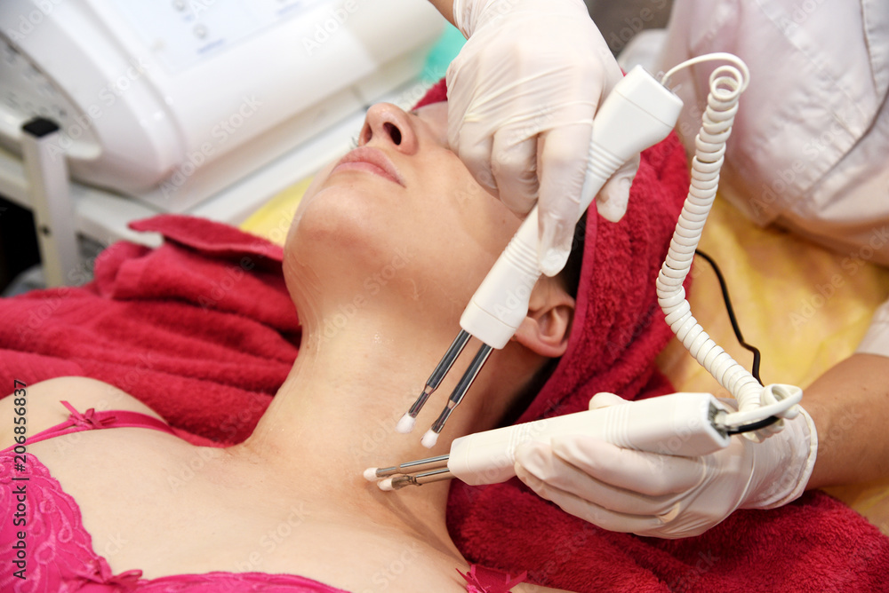 Naklejka premium Microcurrent therapy. Hardware cosmetology. Face rejuvenation. Salon procedure.
