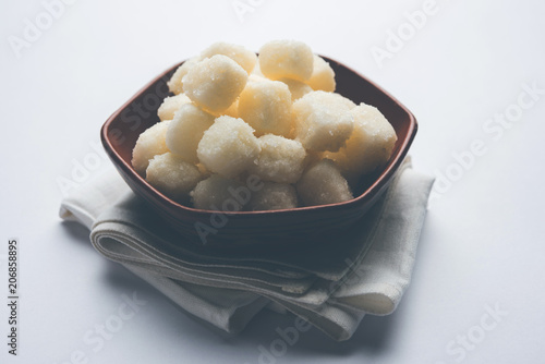 Chena Murki is indian sweet food served in ceramic bowl over moody background. selective focus photo