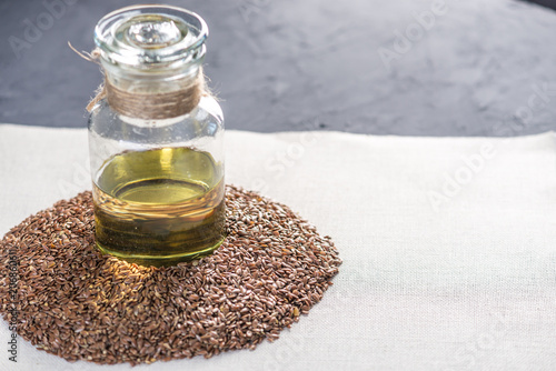 Flax seeds and linseed oil in a glass bottle on the table on a light background. Healthy diet with omega 3 fatty acids.