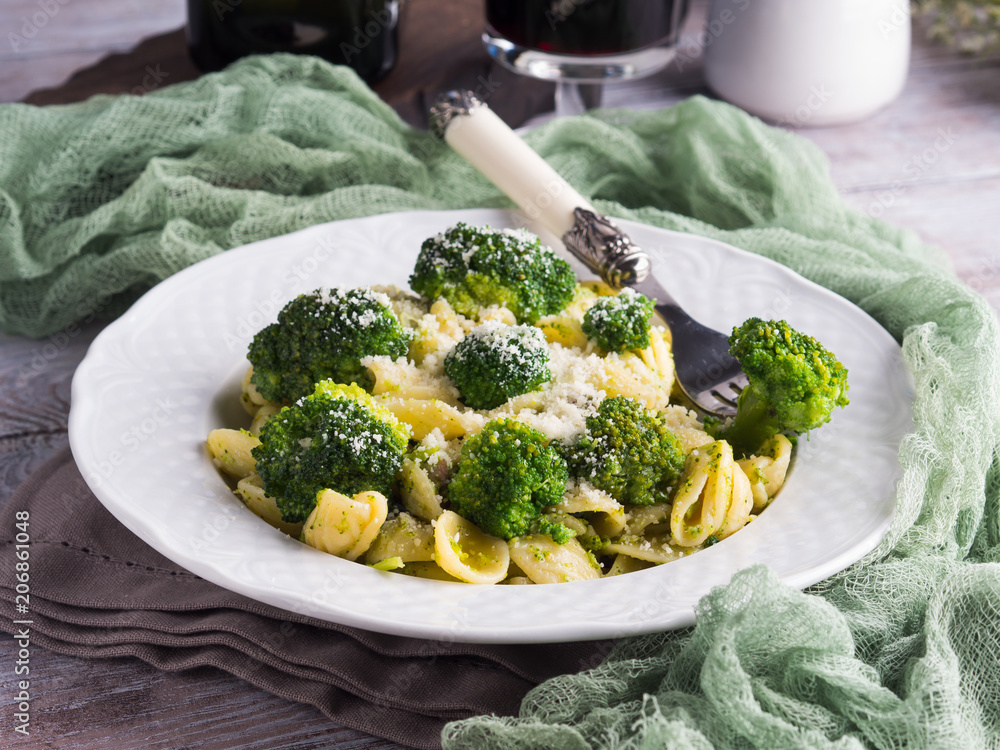 Orecchiette pasta with broccoli in white dish on wooden table. Easy recipe for lunch. Orecchiette pasta with broccoli in white dish on wooden table. Easy recipe for lunch.